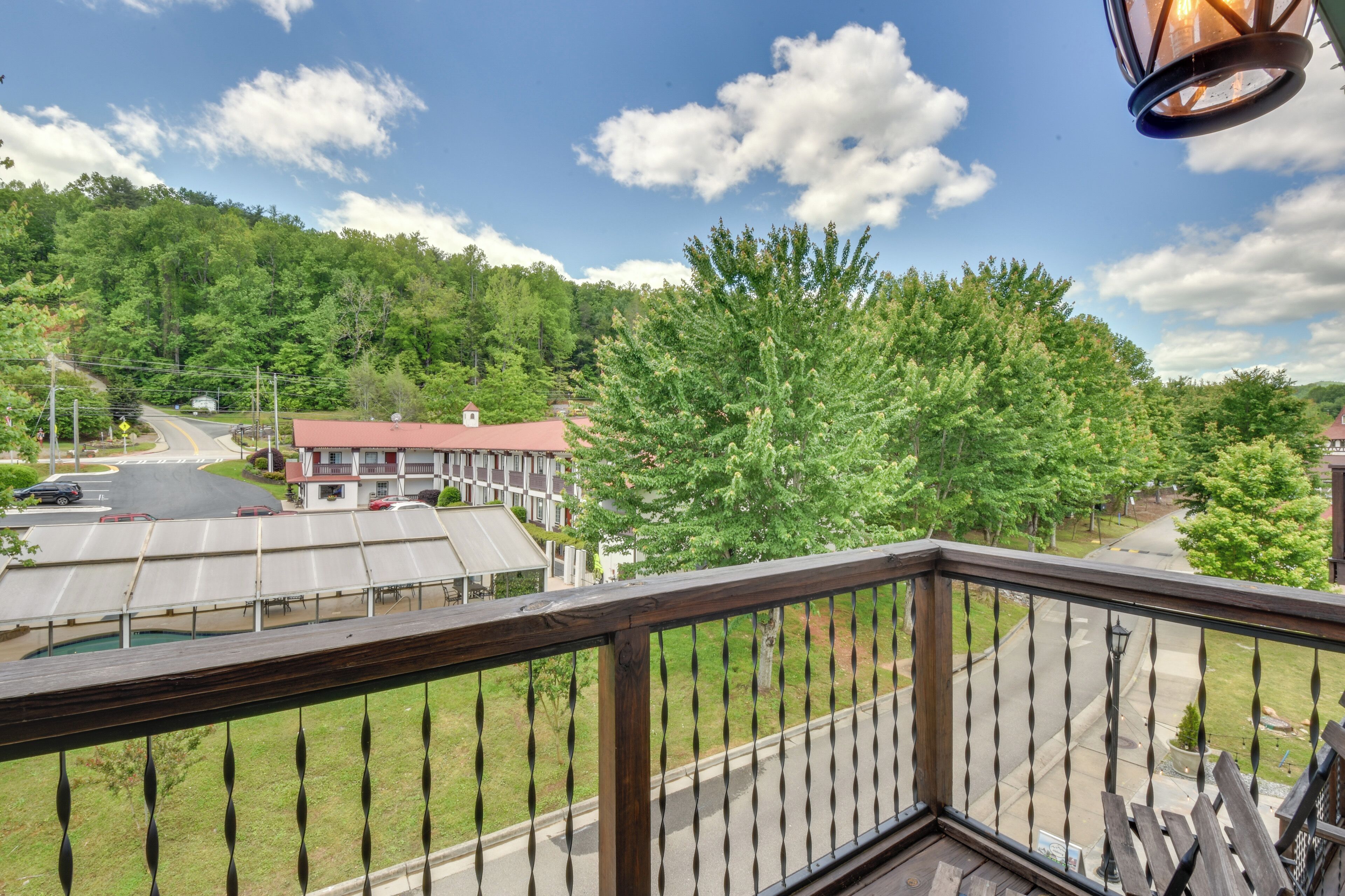 A balcony with a view of a town, including buildings and a road.