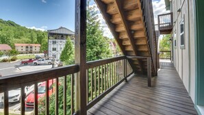 A wooden balcony with a view of a parking lot and buildings. - Walk to Main Street Shops: Helen Escape w/ Balcony (Helen)