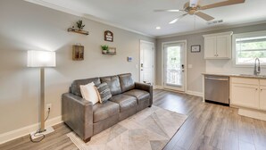 A modern living room with a leather sofa, a standing lamp, and a ceiling fan. - 1 Block to Main St & River: Downtown Helen Condo (Helen)