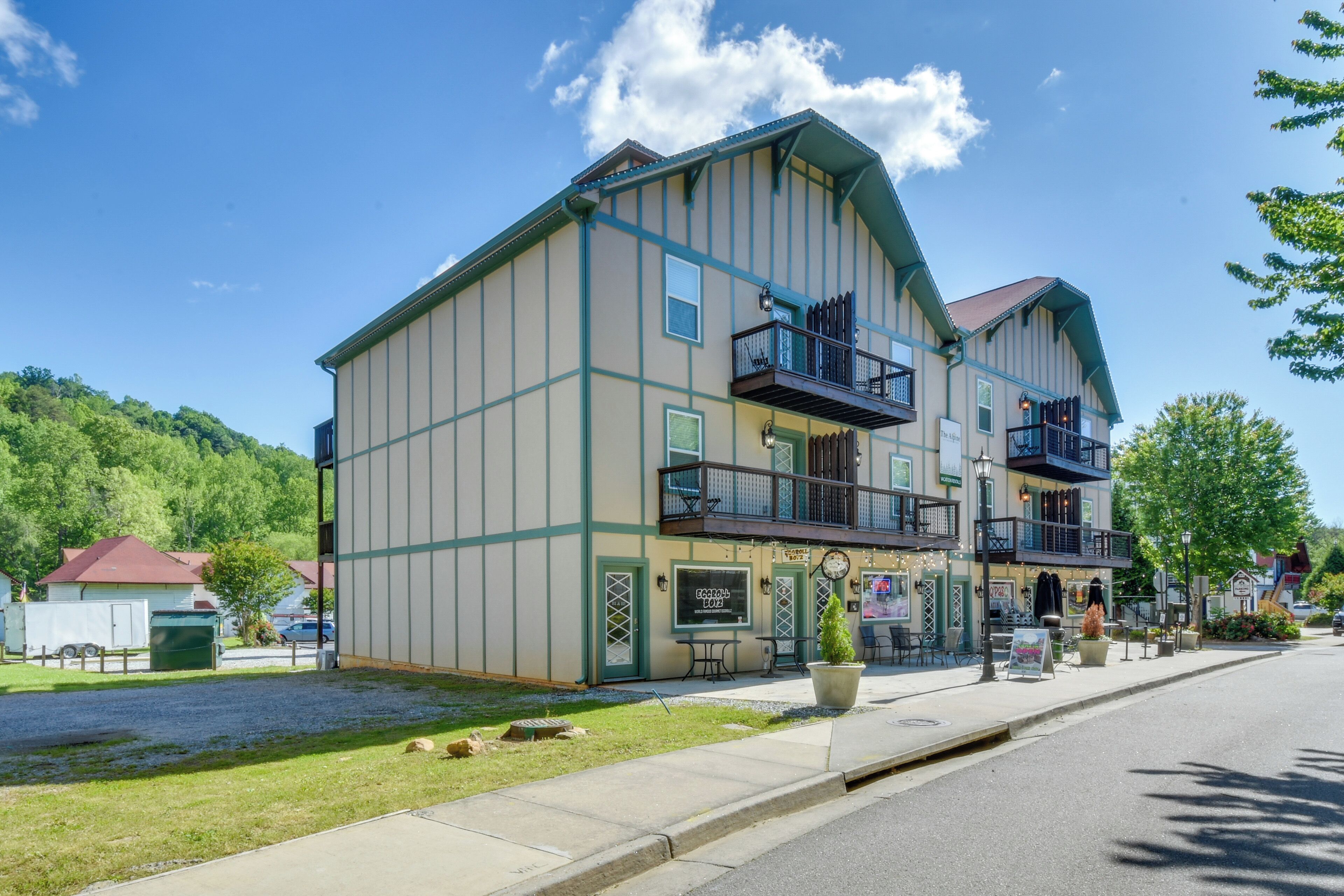 A two-story building with a balcony on the second floor, a sign that reads "COOKHOUSE CAFE," and outdoor seating.