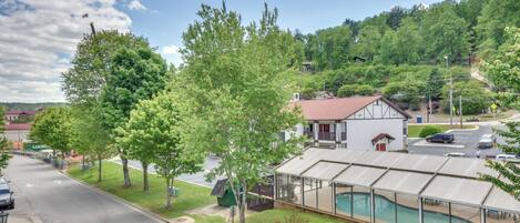 Zona residencial con una casa que tiene piscina cubierta, una calle y vegetación circundante.