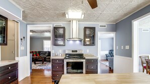 Una cucina con isola centrale, forno a incasso e ventilatore a soffitto.