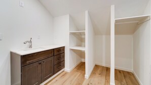 A bathroom with a white vanity, dark cabinets, and a wooden floor. - Fish, Boat & Hike: Modern Portola Studio (Portola)