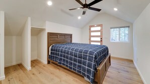 A bedroom with a bed, wooden floor, ceiling fan, and a window. - Fish, Boat & Hike: Modern Portola Studio (Portola)