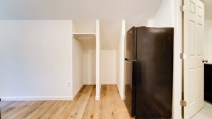 A kitchen with a black refrigerator, wooden flooring, and white walls. - Fish, Boat & Hike: Modern Portola Studio (Portola)