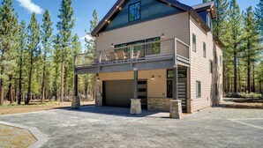 Ein zweistöckiges Haus mit Balkon, Steinpfeilern und Garage.