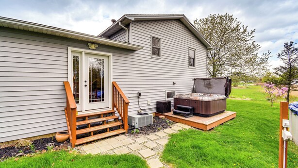 A residential house with a front porch, a hot tub, and a wooden staircase leading to the door. - 3 Mi to Erie Canal: Home w/ Hot Tub in Holley! (Holley)
