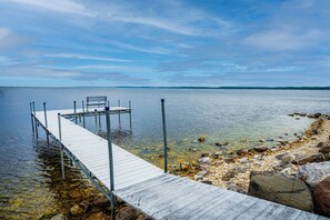 A wooden pier extending into calm water with a bench at the end.