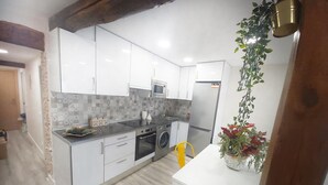 Una cucina moderna con mobili bianchi, un frigorifero in acciaio inossidabile e una lavatrice.