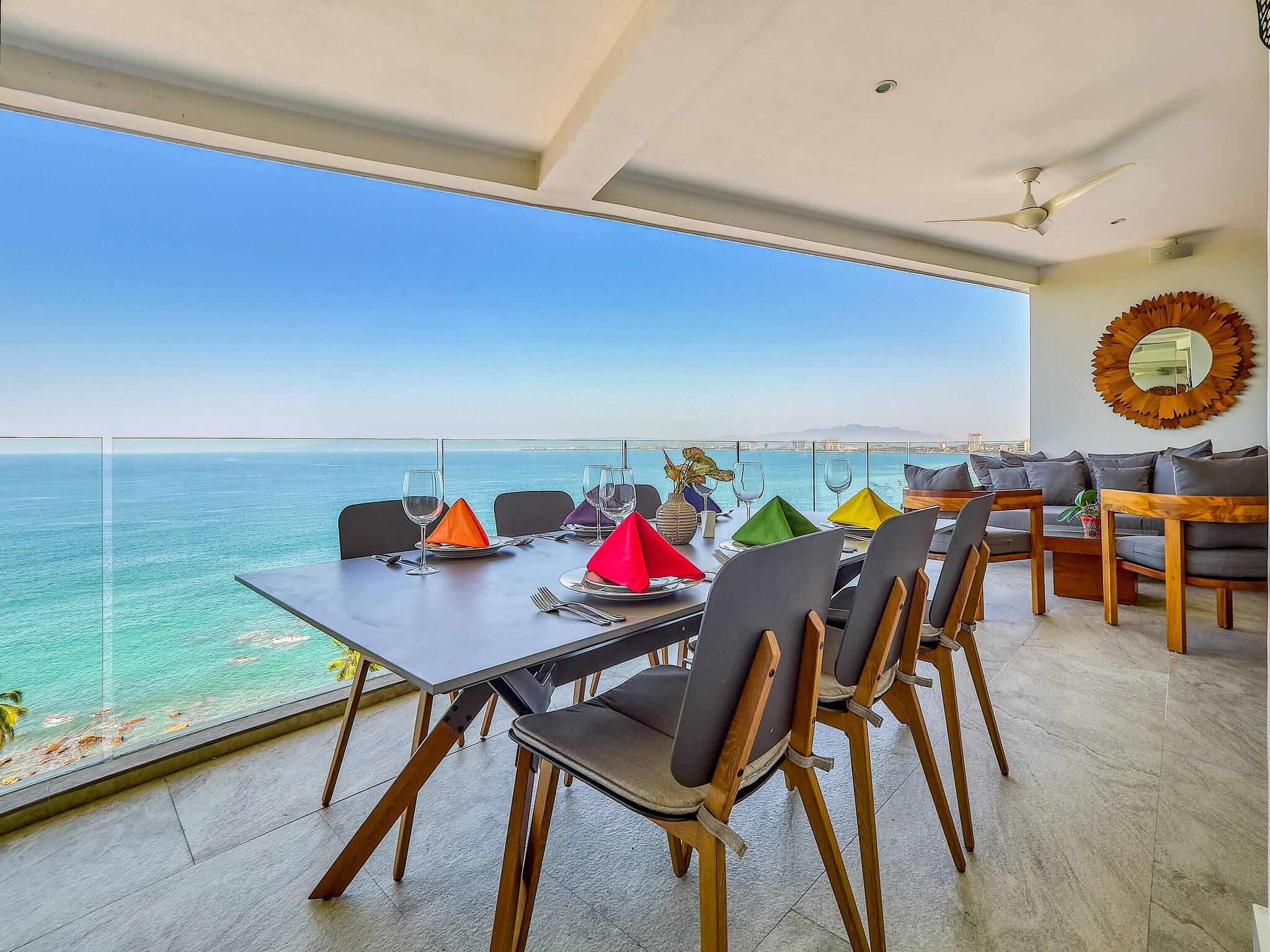 Un coin repas avec une table dressée pour quatre personnes, offrant une vue sur la côte.