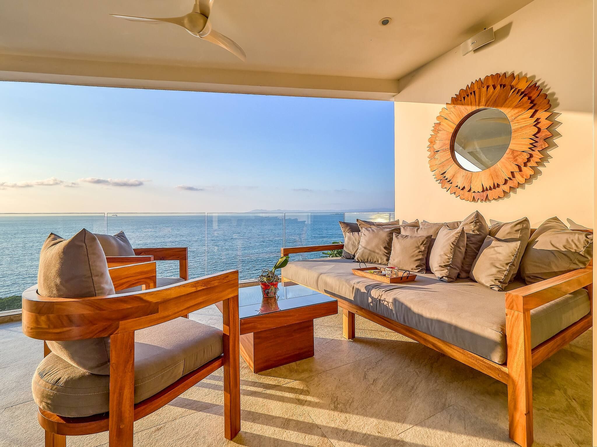 A balcony with a sofa, chairs, and a coffee table.