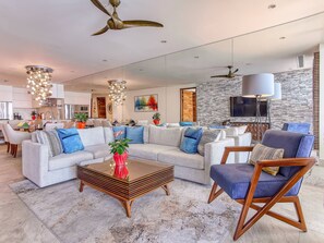 A modern living room with a sectional sofa, a coffee table, and a blue armchair.