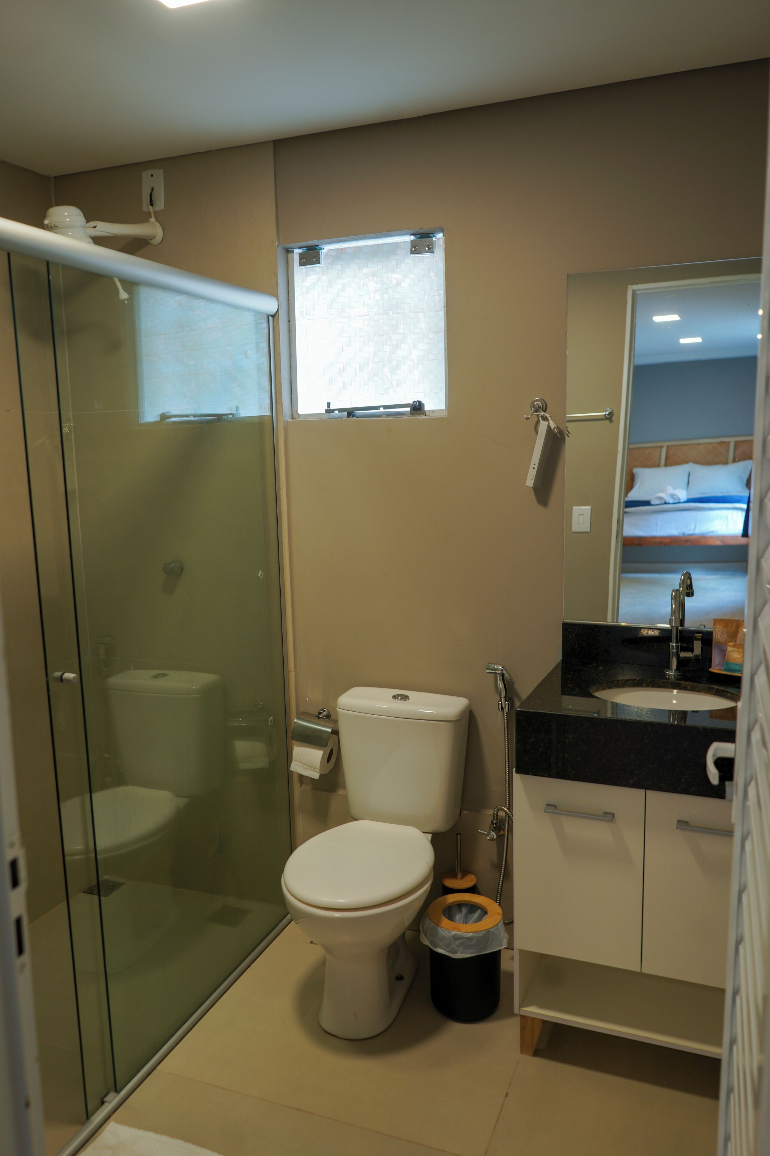 Une salle de bain moderne avec une douche à parois de verre, des toilettes, un lavabo et un miroir.