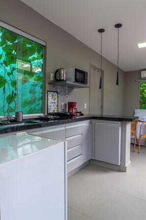 Habitación triple Confort, 1 cama doble con sofá cama, balcón, vistas al jardín | Cocina privada | Microondas y utensilios de cocina