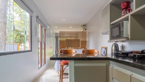 A modern kitchen with a large island, built-in appliances, and a view of the outdoors. - Vila Ecco Cubo (Alto Paraiso de Goias)