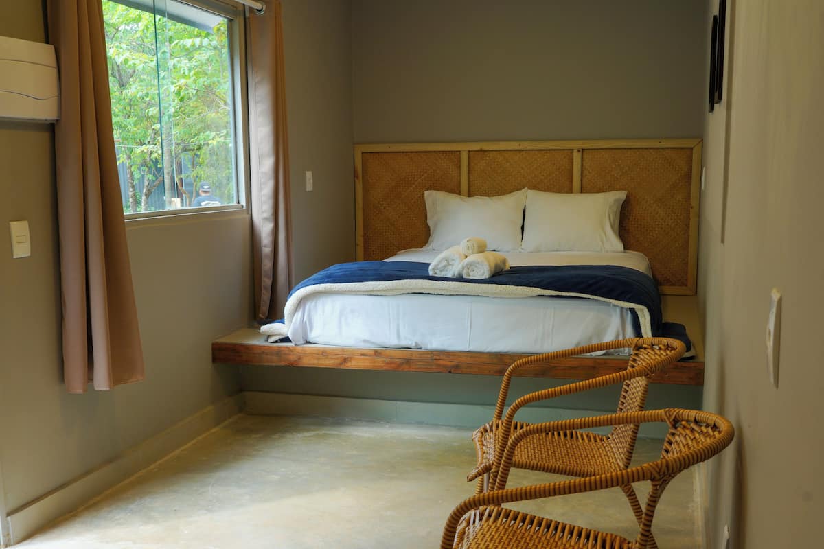 Ein Schlafzimmer mit einem Bett, einem Sessel und einem Fenster.