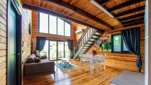A wooden cabin interior with a sofa, dining table, chairs, a staircase, and large windows. - Rubin Sapanca (Sapanca)