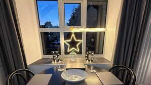 A dining area with a round table, chairs, and a star-shaped light decoration. - Riverside Cottage, Abergwynant (sleeps up to 3) - don't forget your binoculars! (Dolgellau)