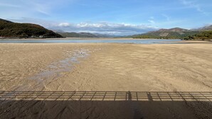 A wide sandy beach with a calm body of water, distant hills, and a clear sky. - Riverside Cottage, Abergwynant (sleeps up to 3) - don't forget your binoculars! (Dolgellau)