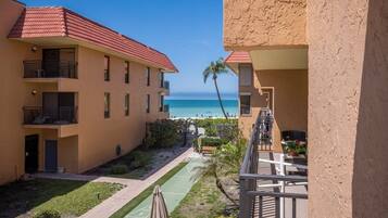 Un edificio de varios pisos con balcones que dan a una playa.