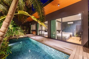 A modern villa with a swimming pool, large sliding glass doors, and tropical plants. - DOJO POOL VILLA 2 BEDROOMS DARK POOL (บางละมุง หนองปรือ)