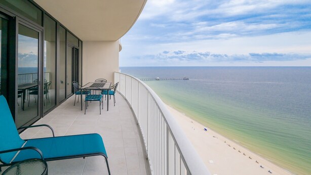 A balcony with a view of the beach and ocean.