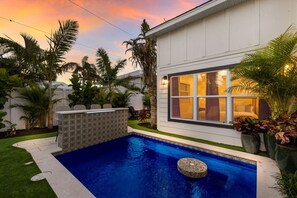 Ein modernes Haus mit Schwimmbad, überdachter Terrasse und gepflegtem Garten.