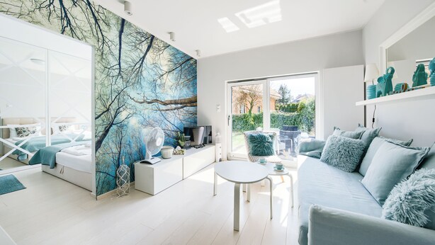 A modern living room with a large window, a sofa, a coffee table, and a TV. - Apartamenty Sun & Snow Nad Zalewem (Dziwnówek)