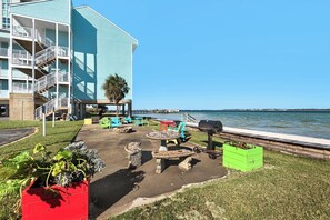 Patio sul lungomare con posti a sedere all'aperto, barbecue e vista sull'acqua.