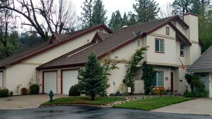 A two-story residential building with a garage, a satellite dish, and a well-maintained lawn.