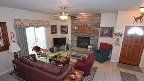 A living room with a fireplace, a television, and a sofa.