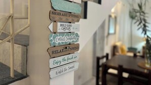 A wall with multiple wooden signs, each with a different message. - Tropical 3-bedroom villa 5 min from the beach, perfect for families (Flic en Flac)