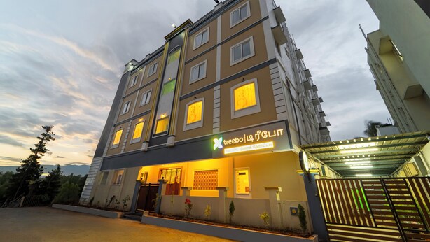 Hotel de vários andares com design moderno, destacando uma entrada imponente e sinalização iluminada.