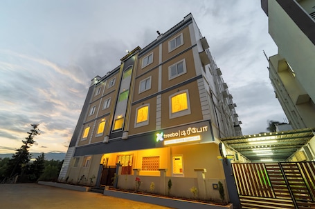 A multi-story hotel with a modern design, featuring a prominent entrance and illuminated signage.