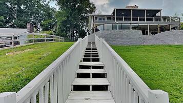 A wooden staircase leading to a building with a flat roof and a stone wall.