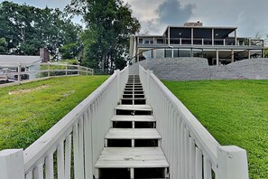 Un escalier en bois mène à un bâtiment doté d’un toit plat et d’un mur en pierre.