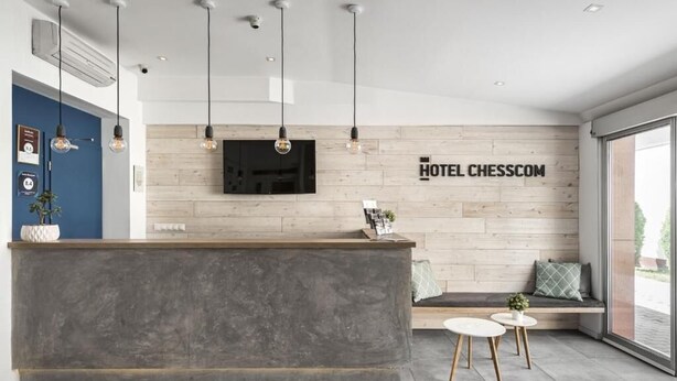 Ein moderner Hotel-Empfangsbereich mit einer Holzwand, einem Flachbildfernseher und einer Rezeption.