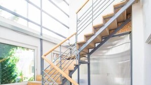 Eine moderne Treppe mit Holzboden und Metallgeländern, die zu einer oberen Etage führt.