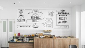 Eine moderne Küche mit einer Frühstückstheke, ergänzt durch Wandkunst mit Begriffen wie 'Kaffee', 'Schinken und Eier' und 'Cereal'.