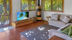 Een woonkamer met een televisie, bank en open haard.