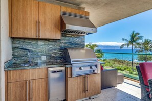 Eine Küche mit integriertem Grill, einem Geschirrspüler und Meerblick.