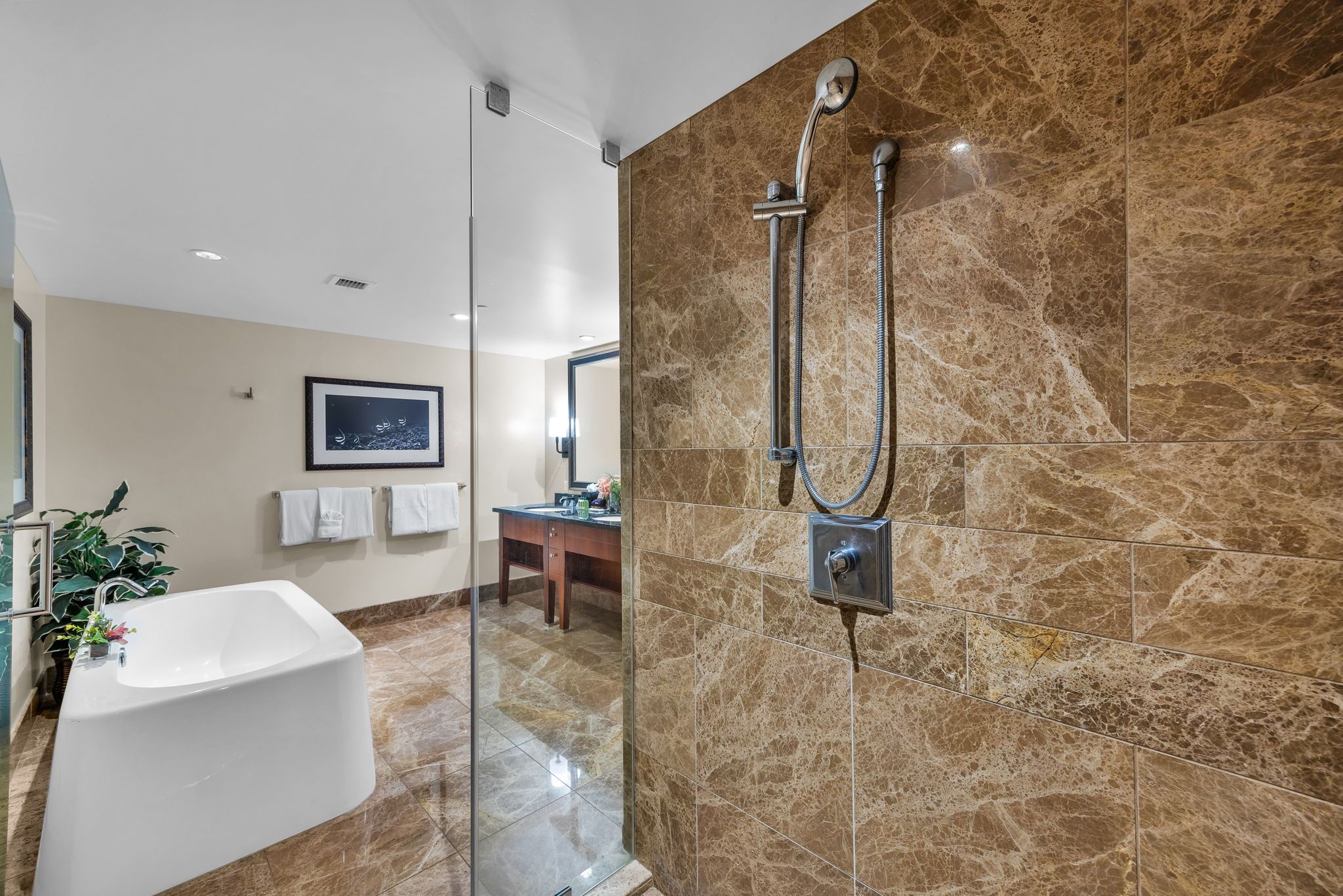 Une salle de bain moderne dotée d’une douche à parois de verre, d’une baignoire sur pieds et d’un meuble-lavabo avec un miroir.