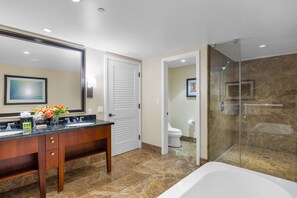 A modern bathroom with a double sink vanity, a large mirror, a shower with glass doors, and a toilet.