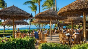 A resort with thatched umbrellas, wooden chairs, and a view of the ocean. - Honua Kai | Ocean View 6 BR, Sleeps 18 | Car Incl. w/ 6+ Nights | HKH ML-1115 by KBM (Lahaina)