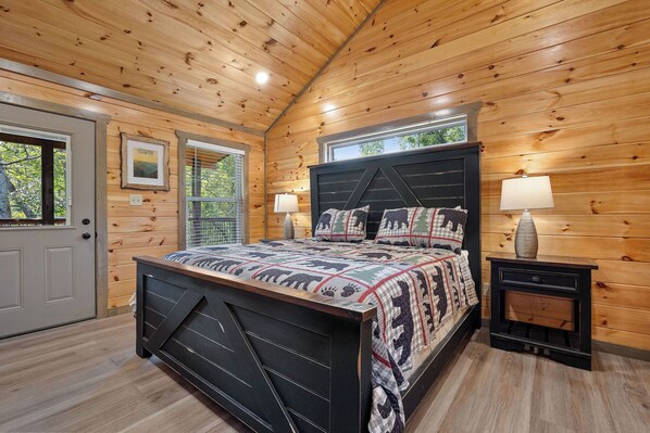 A wooden-paneled bedroom with a bed, two bedside tables, a window, and a door. - The Best Memories Are Made Of Splashing (SEVIERVILLE)