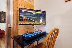 Un ensemble de jeu comprenant un écran, un joystick et des boutons d’arcade, le tout installé sur une table.