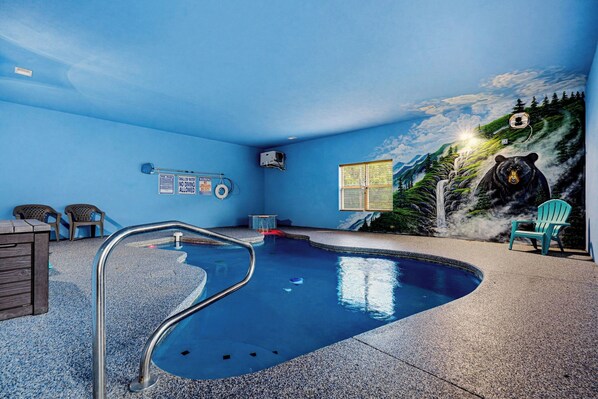A swimming pool with a bear mural, chairs, and a window. - More than Swimming in the Smokies (Seymour)