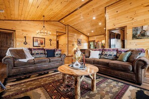 L’intérieur d’un chalet confortable, avec deux canapés en cuir, une table basse en bois et un tapis à motifs.
