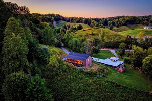 A large, two-story building with a flat roof, surrounded by lush greenery and hills. - More than Swimming in the Smokies (Seymour)