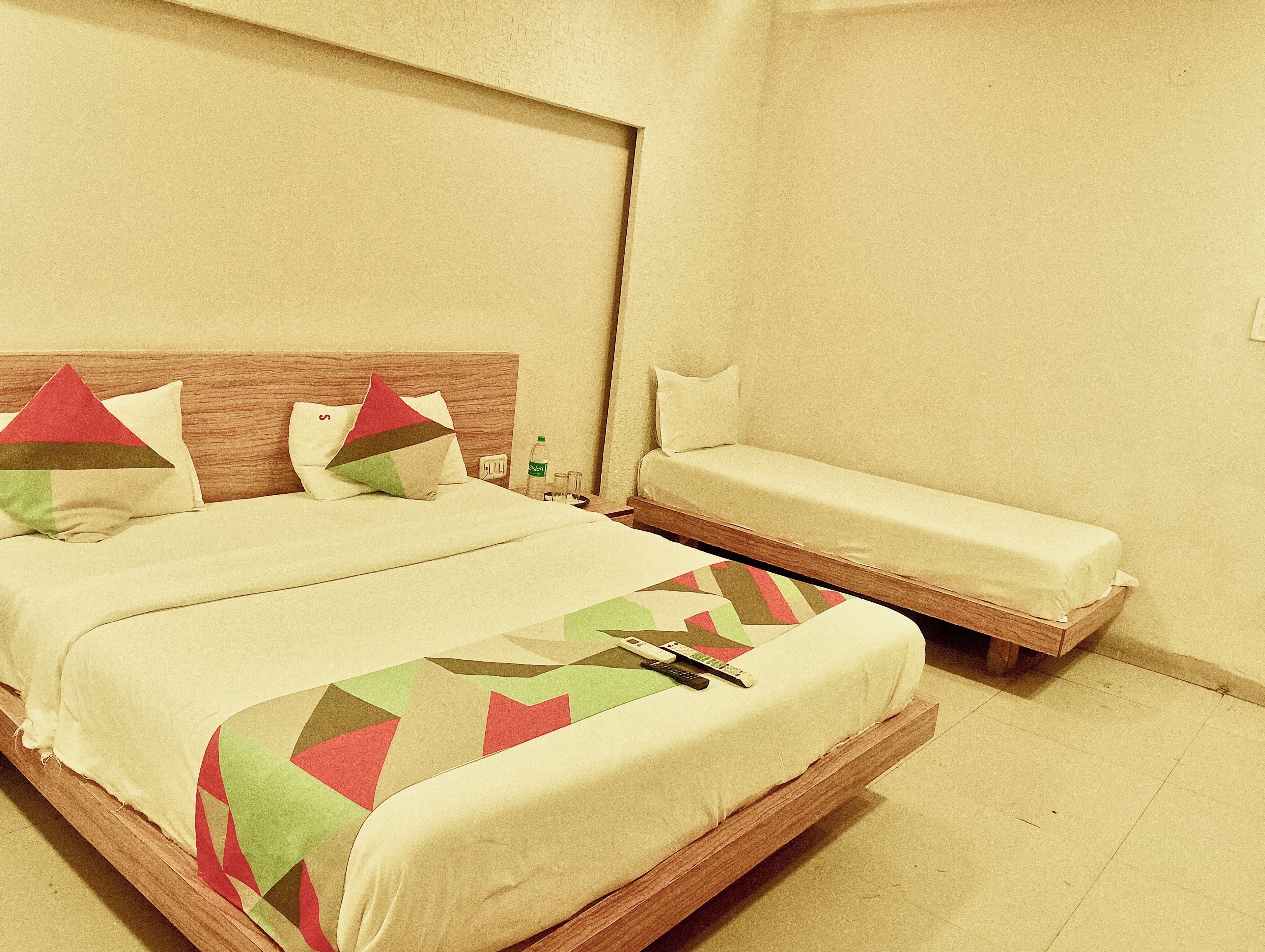 Une chambre d’hôtel avec un lit double et un lit simple.
